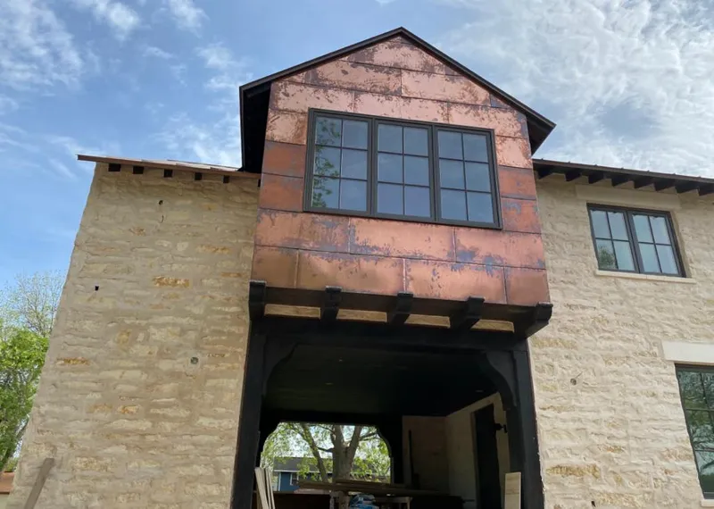 Copper metal panel facade on a stone building for Roof Repair in Carrollton